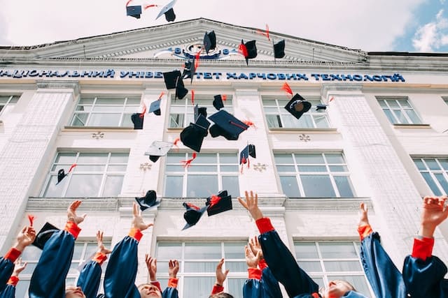 Excited students tossing their graduation hats in the air, filled with anticipation for their future endeavors in New Zealand