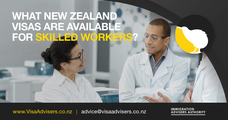 Two professionals happily discussing their New Zealand work visa options while dressed in lab coats.